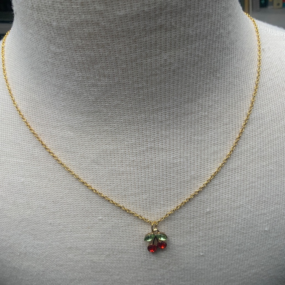 Gold-colored necklace with cherry charm